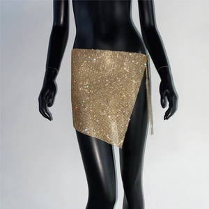 Détail d'une mini-jupe dorée en strass avec fente latérale et chaîne à franges