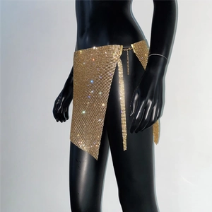 Vue détaillée de la mini-jupe en maille de strass dorés avec fente et chaîne de taille