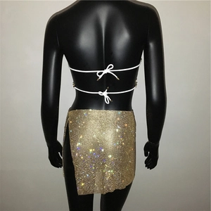 Detailansicht goldener Paillettenrock mit Seitenschlitz und weißem Bikini-Oberteil