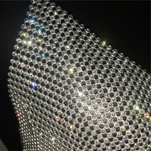 Close-up of sparkling rhinestones on silver mesh fabric for a luxury party top