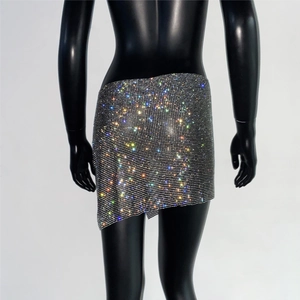 Gros plan sur une mini-jupe en strass colorés avec ourlet asymétrique et base argentée