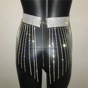 Macro detail of silver rhinestone fringe waist chain on a model for beach and party wear