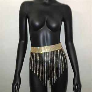 Detail showing gold rhinestone tassel waist belt with sparkling fringes on a black dress
