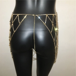 Detailed close-up of golden geometric rhinestone body chain with shimmering crystal grid