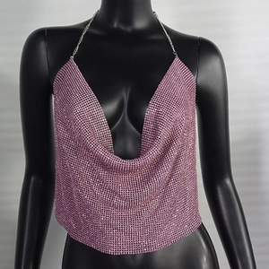 Detailed close-up of pink sequins and silver chain on a metallic halter neck top