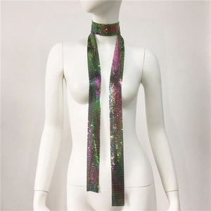 Dettaglio della sciarpa con paillettes metalliche sfumate viola e verde su manichino