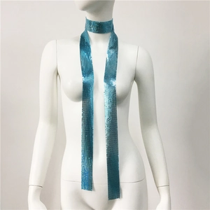 Dettaglio della sciarpa in paillettes metalliche blu brillante con lunghe stringhe