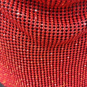 Macro shot of high-density red rhinestone mesh with polished metal chain links