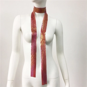 Dettaglio della sciarpa a rete con paillettes sfumate rosa e arancione su manichino