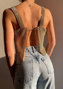 Detail of gold metal mesh crop top with halter backless chain closure and sparkly texture
