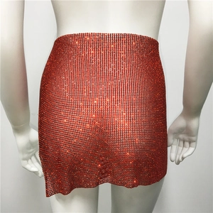 Détail de la mini-jupe en résille de strass rouges montrant la texture de la chaîne