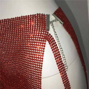 Vue macro des strass rouges et du fermoir métallique sur ce haut de fête sexy