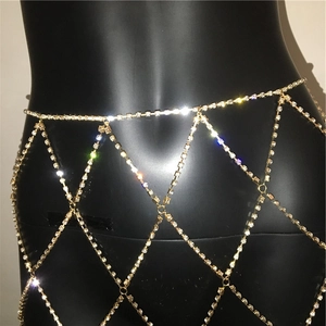 Detail shot of sparkling rhinestone mesh body chain on a black mannequin with gold finish