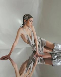 Close-up of silver metal sequin halter dress with reflective mirror effect and boots