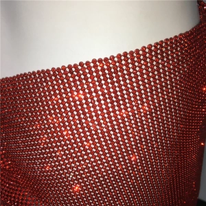 Détail du tissu en maille métallique à strass rouges avec cristaux étincelants