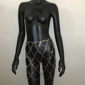 Detail of golden rhinestone fishnet body chain skirt on a black mannequin for parties