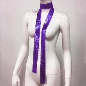 Dettaglio della sciarpa choker con paillettes viola e texture metallica su un manichino