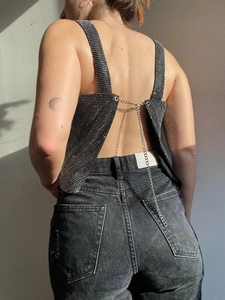 Detail view of sparkly black rhinestone crop top with criss-cross back chain straps