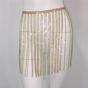 Detailed view of golden rhinestone fringe body chain skirt on a white mannequin
