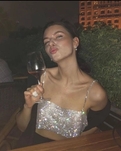 Détail d'un crop top argenté scintillant avec strass et fines bretelles de soirée