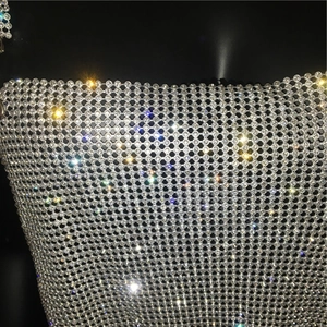 Macro shot of sparkling rhinestone mesh fabric detail on a sexy metallic silver top