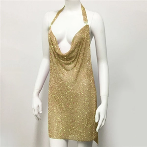 Detailed close-up of shiny gold sequin mesh fabric on a sexy halter neck party dress