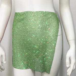 Détail du tissu en maille de strass vert clair sur une mini-jupe sexy