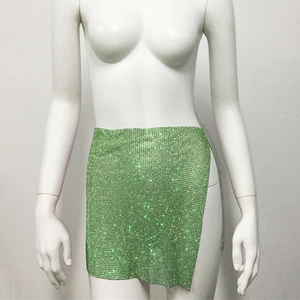 Gros plan sur les strass verts scintillants de la mini-jupe sexy pour soirée club