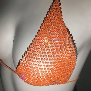 Detail eines orangefarbenen Bikini-Oberteils mit funkelnden Strasssteinen und Trägern