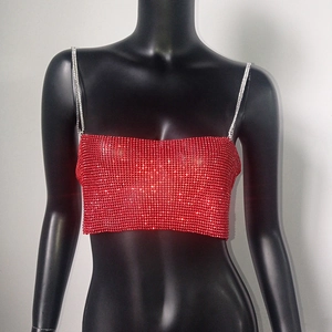 Détail d'un haut rouge avec strass brillants et fines bretelles en chaîne métal