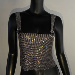 Detail of colorful rhinestones on black mesh cropped tank top for party wear