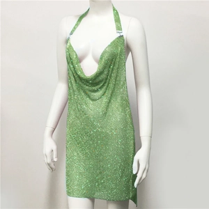 Macro detail of grass green sequin mesh with sparkling rhinestones on the V-neckline