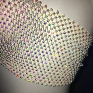Macro detail of rhinestone mesh crop top showing sparkling AB crystals on white netting