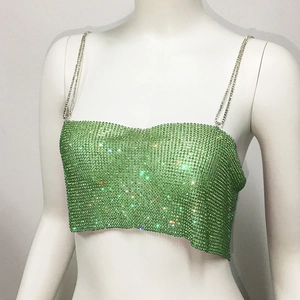 Détail d'un haut court en strass vert avec bretelles en chaîne métallique argentée