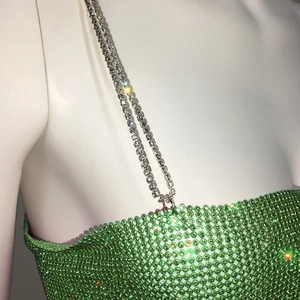 Détail du haut en maille métallique à strass verts avec bretelles chaîne en argent