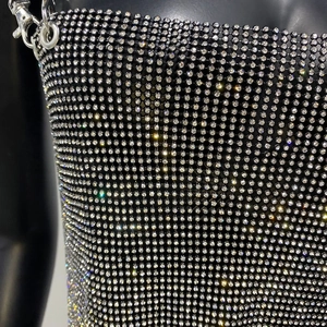 Close-up of sparkling silver rhinestones on black mesh fabric with metal buckle detail