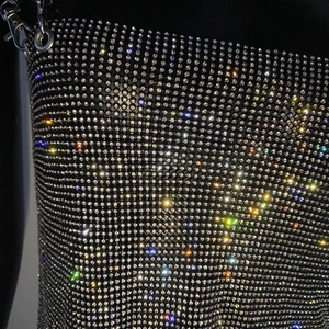 Detail of sparkling rhinestones on black mesh fabric with silver metal carabiner clip
