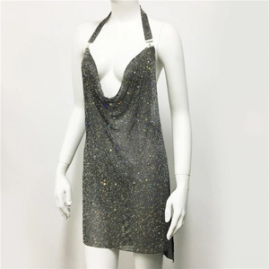 Macro shot of shimmering metal mesh sequins and deep V-neck detail on party dress