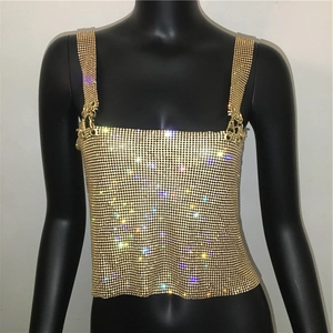 Detailed close-up of golden rhinestone crop top featuring metallic mesh and buckle straps
