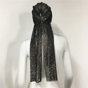 Detail of black mesh headscarf with multicolored rhinestones and long fringe tassels