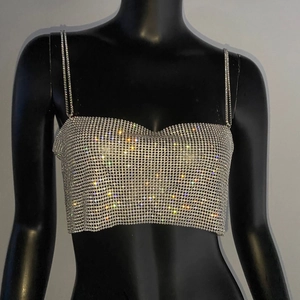 Détail d'un haut court en maille strass argentée brillante avec fines chaînes en métal