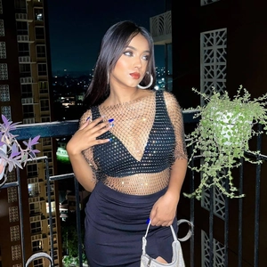 Close-up of sparkling rhinestones on black mesh fishnet top for women's party wear