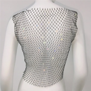 Detail of silver mesh vest featuring sparkling rhinestones and delicate metal grid work