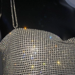 Gros plan détaillé de la maille en strass argentés et des bretelles en chaîne du haut