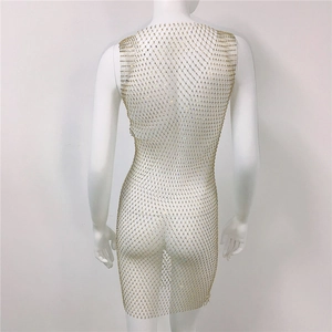 Détail de la maille à strass dorés sur la robe moulante sexy avec découpes en résille