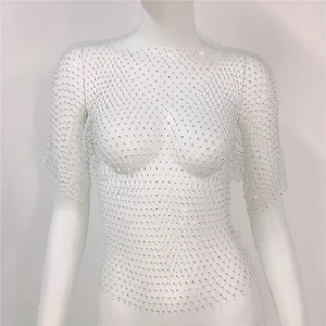 Détail du haut en maille résille blanche orné de strass brillants et texture ajourée