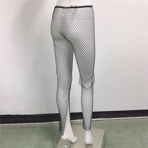 Gros plan du pantalon résille noir orné de strass brillants avec fentes latérales
