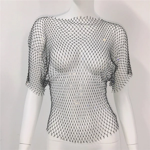 Détail du haut en maille noire avec des strass étincelants et structure résille