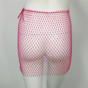 Détail de mini-jupe en résille rose avec strass brillants et fermeture à nouer sur le côté