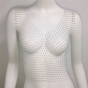 Macro detail of the sparkling rhinestones on the white mesh sleeveless crop top vest